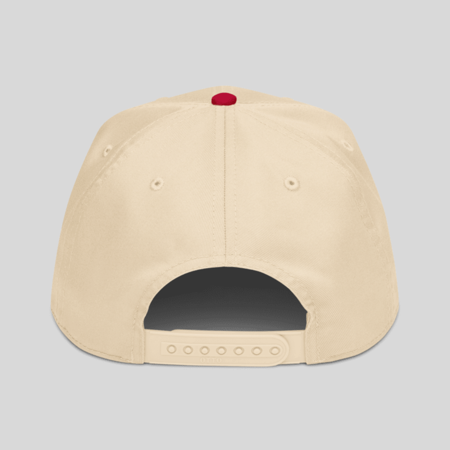 The back view of a beige snapback cap with a small red button on top, shown against a solid gray background.