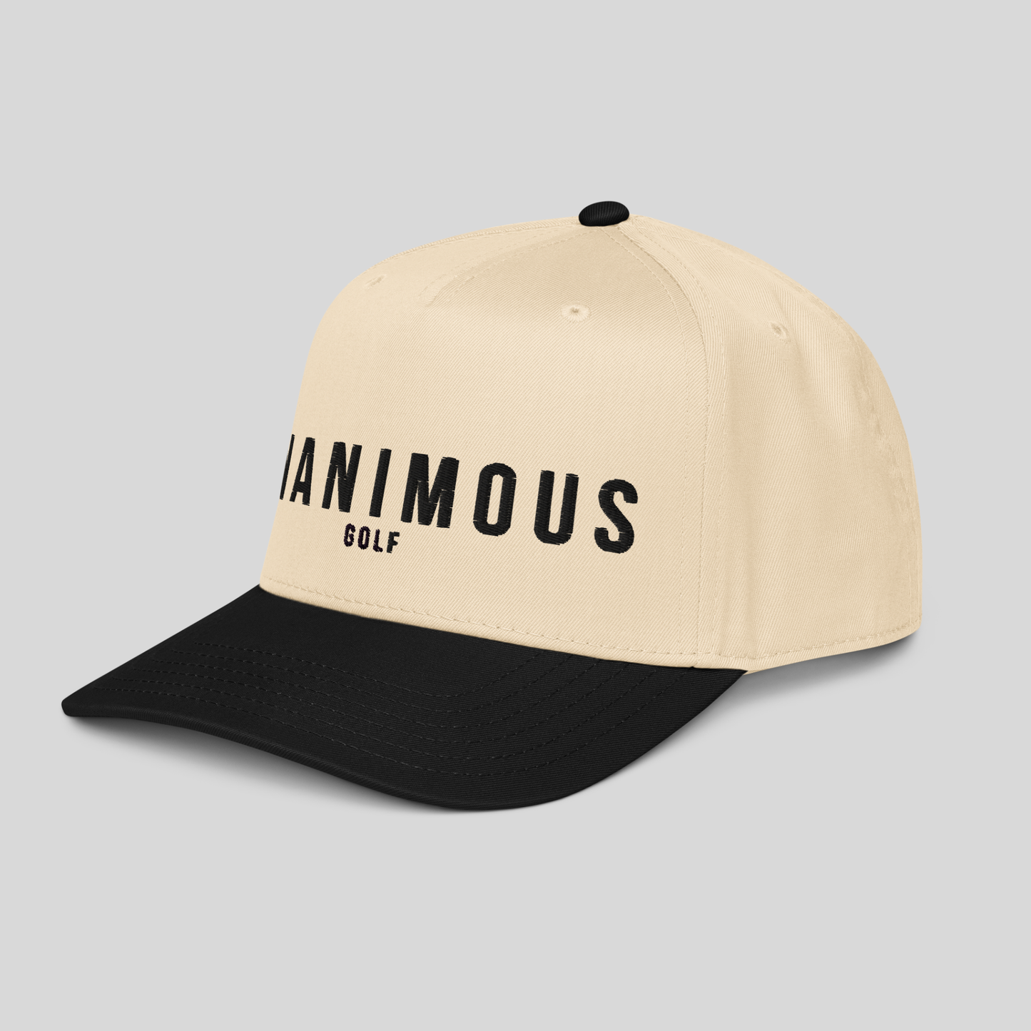 A structured baseball cap with a cream-colored crown and a black curved brim. The front of the cap features the text UNANIMOUS GOLF' printed in black.