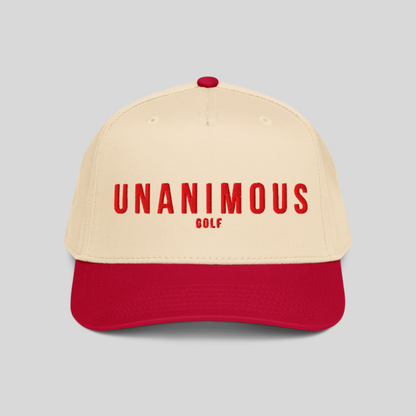 A two-tone baseball cap with a cream-colored crown and a red visor, featuring the text 'UNANIMOUS GOLF' in red on the front. The cap is shown against a solid light gray background.