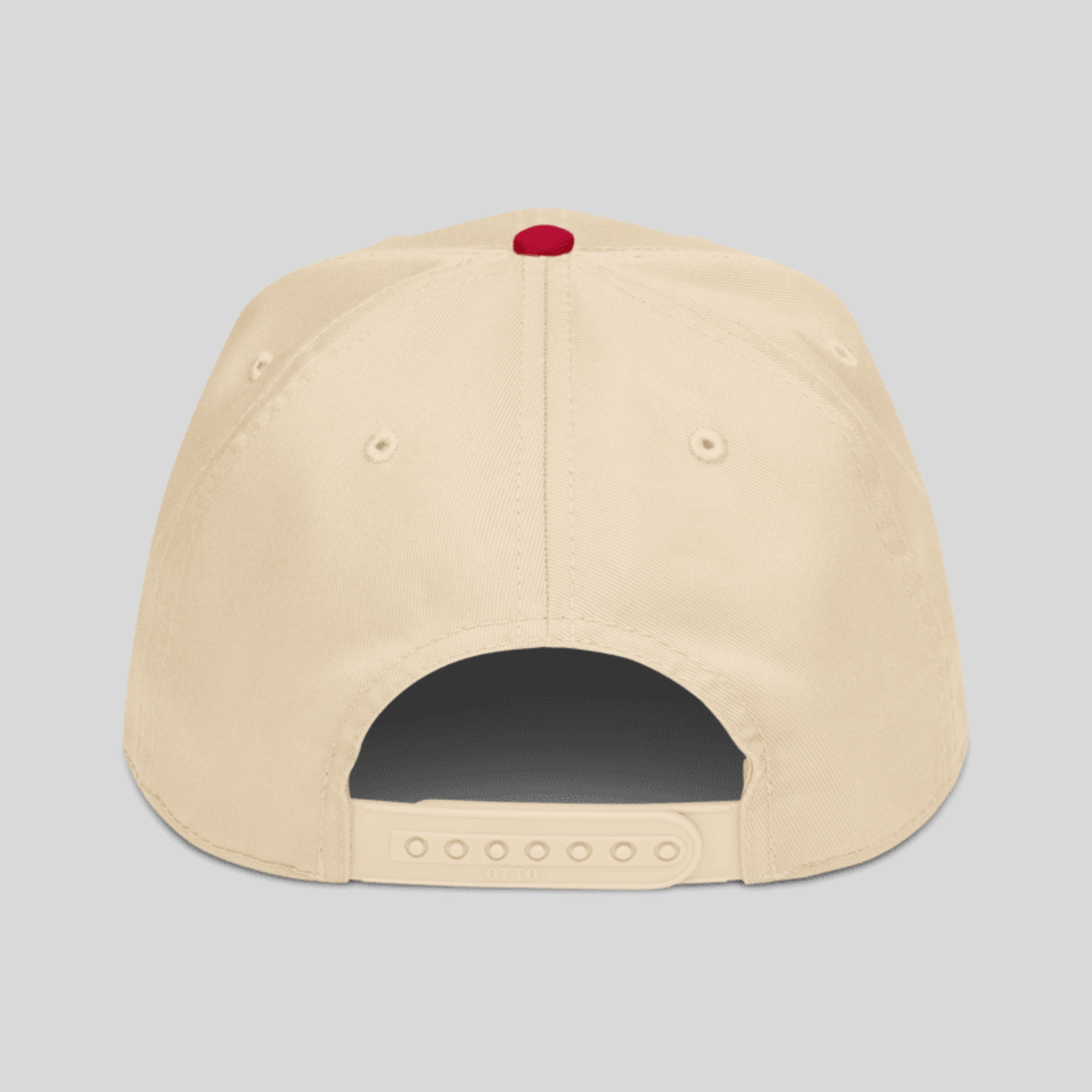 The back view of a beige snapback cap with a small red button on top, shown against a solid gray background.